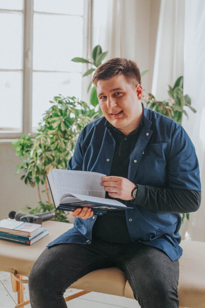 Fizjoterapeuta Łukasz Kusowski czytający książkę