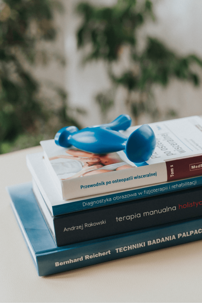 książki o fizjoterapii leżące na łóżku