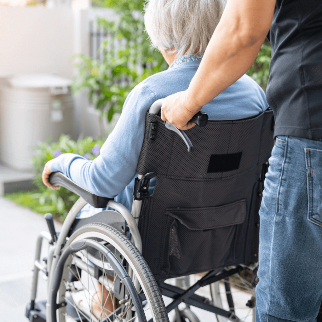 starsza osoba jadąca na wózku inwalidzkim
